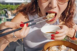 Girl Enjoying Mince and Dumplings with Chopsticks