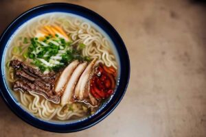 A bowl of steaming ramen adorned with an assortment of toppings.
